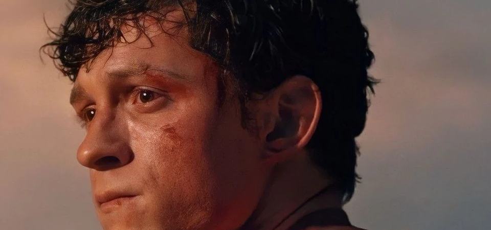 Tom Holland's Peter Parker in close-up, face scraped and bruised, eyes wet