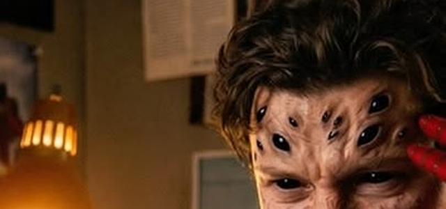 Tom Holland as Peter Parker, mask off and face cut, sitting under a desk lamp